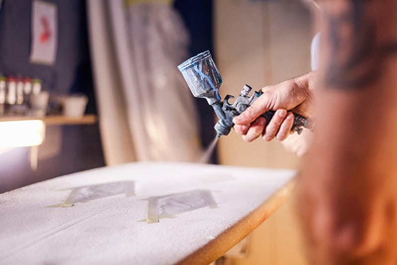 spray painting surfboard