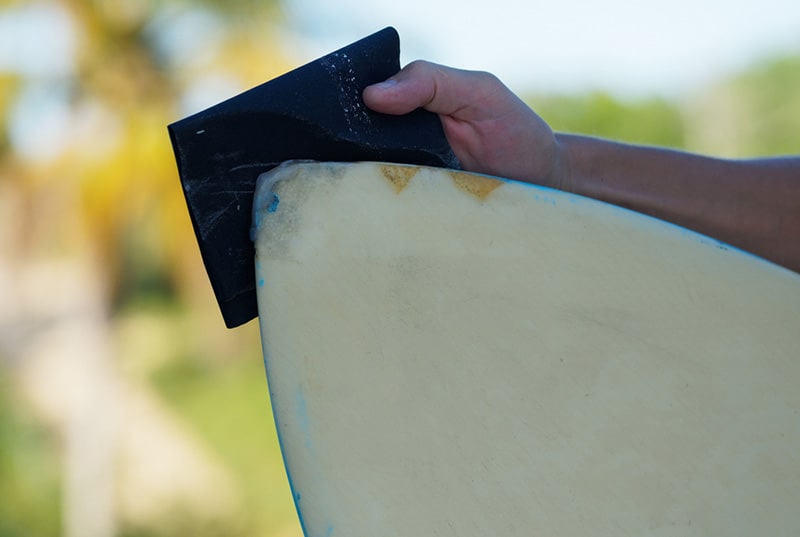sand the ding of surfboard with the rough sandpaper