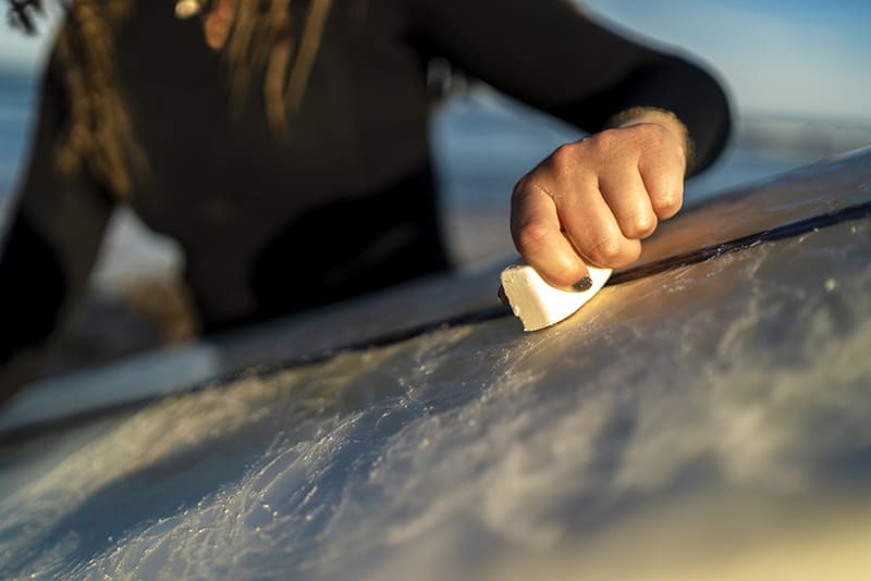 Waxing-the-surfboard-at-the-beach